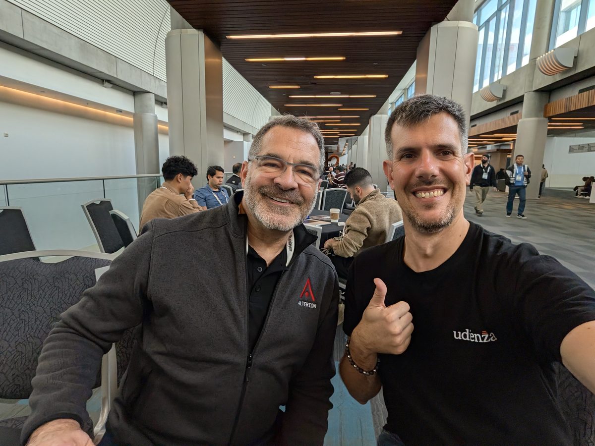 Sanford Redlich and Luca Berton giving a thumbs-up in a bright corridor of the convention center