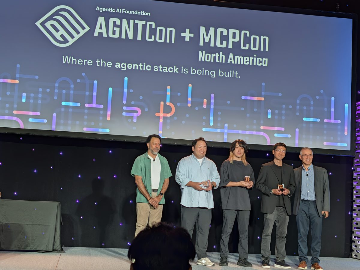 Mazin Gilbert with four people standing in a row on the keynote stage during the awards, under the AGNTCon + MCPCon screen