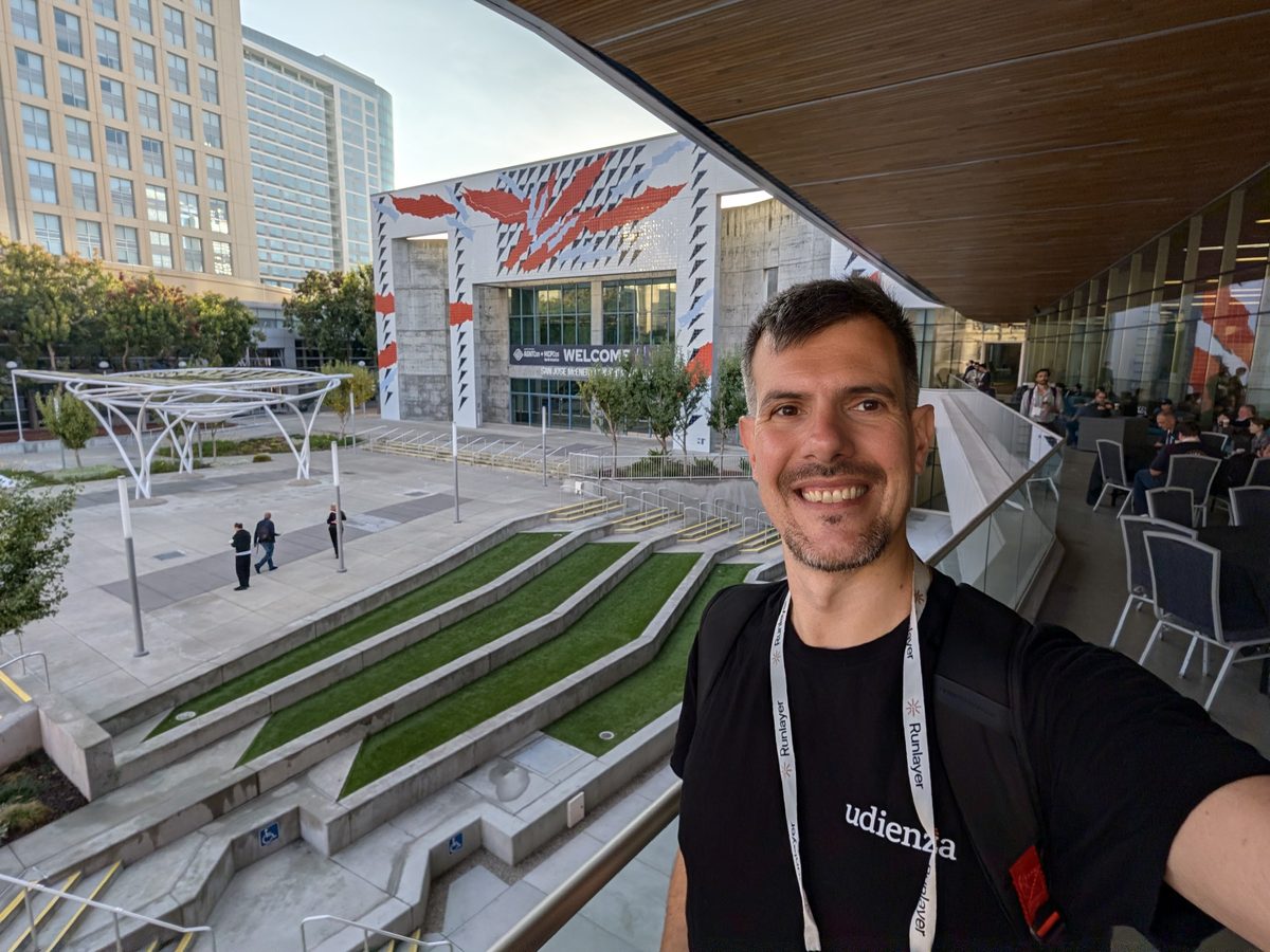 Luca Berton in an Udienza T-shirt and an AGNTCon lanyard, taking a selfie on the terrace of the San Jose McEnery Convention Center