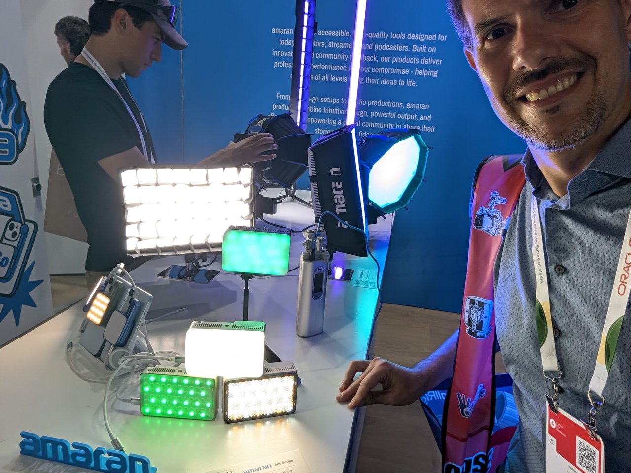 The amaran stand at IBC, with a row of compact LED panels lit in white and green