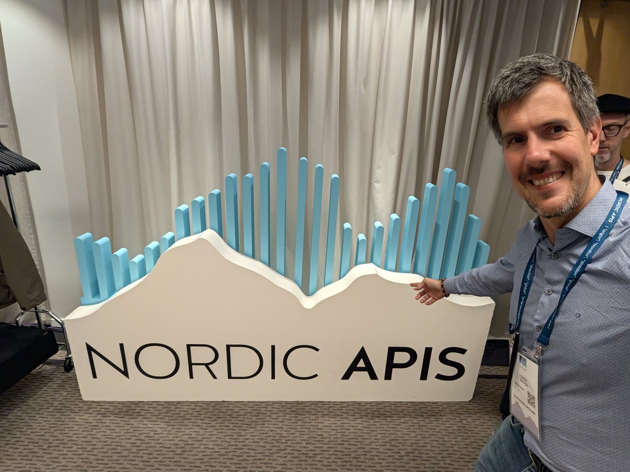 The host beside the Nordic APIs Summit sign at the Clarion Hotel Stockholm