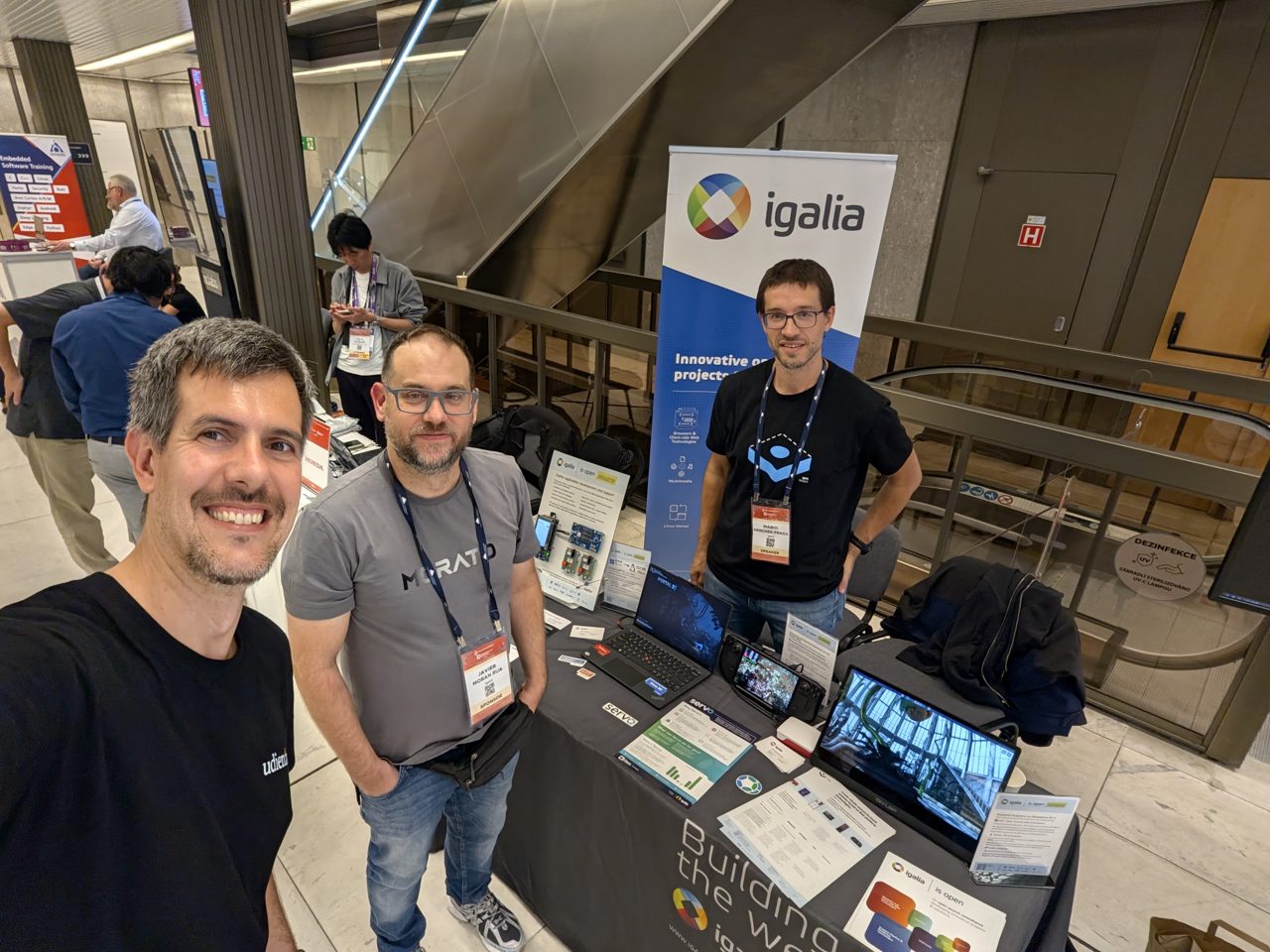 The host at the Igalia booth with members of the Igalia team