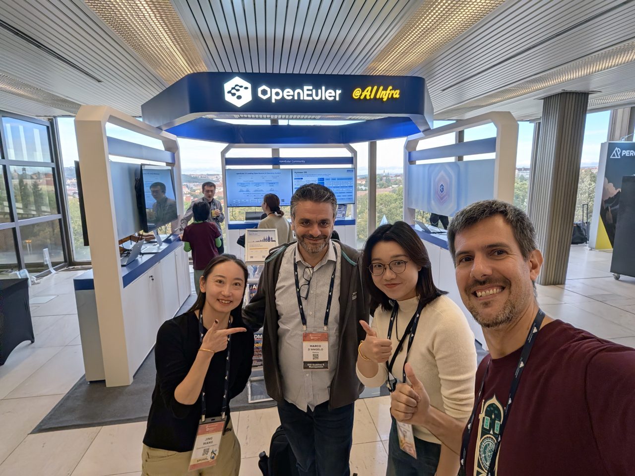 The host with the openEuler team at their booth