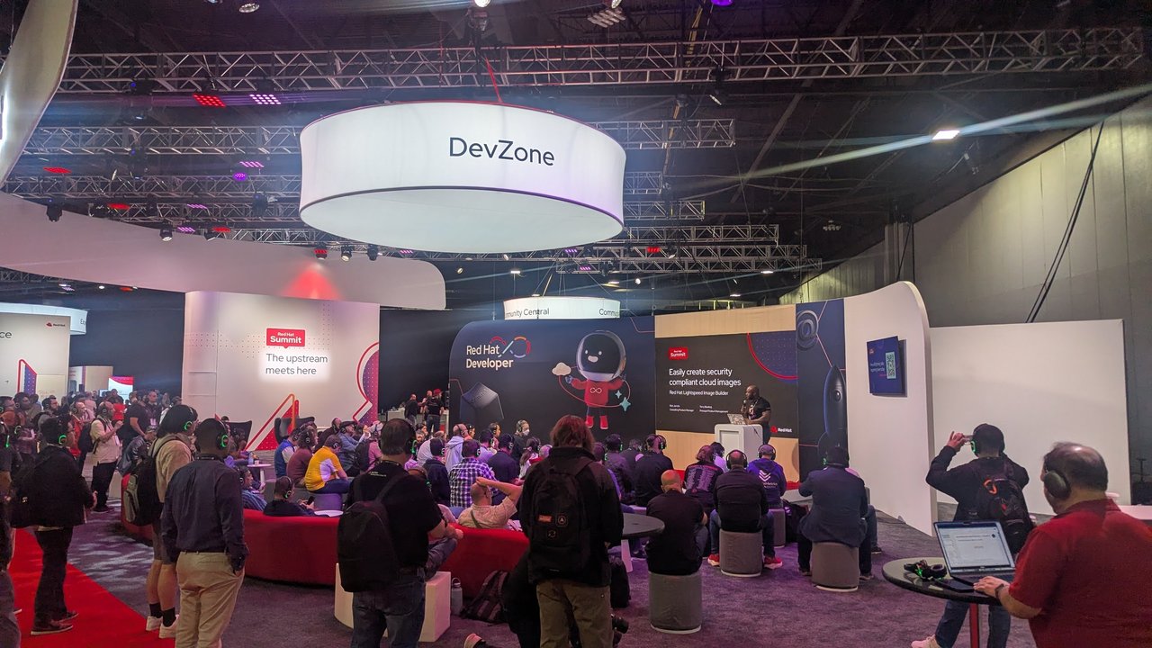 The DevZone area at Red Hat Summit, crowded with attendees wearing green headphones for a silent-disco style session